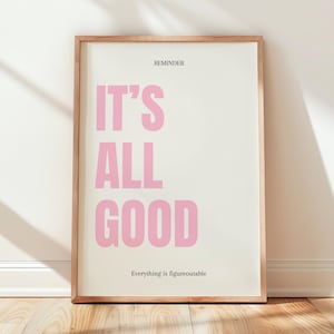 Può includere: Una stampa artistica rettangolare in una cornice di legno chiaro con sfondo color crema, che riporta il testo REMINDER in alto, la frase IT'S ALL GOOD in grandi lettere maiuscole rosa al centro e il testo Everything is figureoutable in basso.