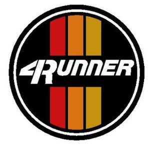 May include: A circular emblem featuring a black background with three vertical stripes in red, orange, and yellow. The white text 4RUNNER is centred horizontally across the middle of the circle, with a thick white border outlining the entire design.