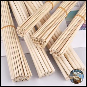 Könnte beinhalten: Mehrere Bündel dünner, hellfarbiger Holzstäbe, die mit braunen Gummibändern zusammengehalten werden. Die Stäbe sind gerade und von einheitlicher Größe, geeignet für Bastelarbeiten oder Modellbauprojekte. Das Bild zeigt mehrere Bündel.