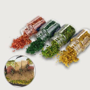 May include: Four small glass jars tipped over, each dispensing a different colour of miniature foliage. Colours include red, green, light green, and yellow. A miniature diorama is in the lower left corner, showing a military scene.
