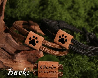 May include: Two dog collars with wooden accents. One collar is brown, the other is black. Each collar has a wooden square with a black paw print. The back of one collar is engraved with the name "Charlie" and the date "02.09.2025".