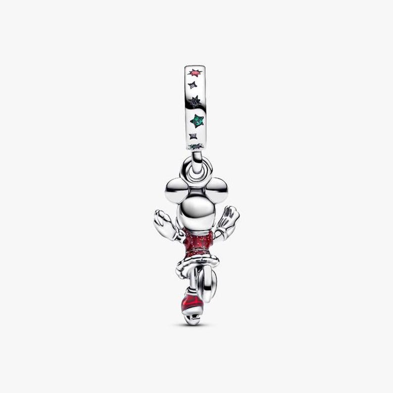 May include: A silver charm featuring a cartoon character in a red dress and hat. The charm has a Mickey Mouse head design and is decorated with red and green stars. The charm is suspended from a silver loop.