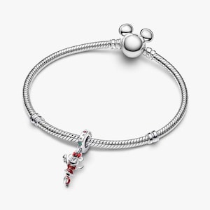 May include: A silver bracelet with a Mickey Mouse charm. The charm is red, white, and black with green accents. The bracelet has a round clasp with Mickey Mouse ears.