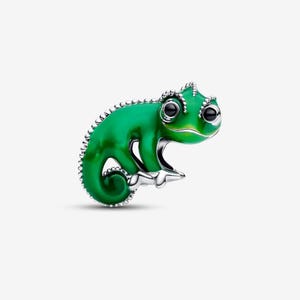 May include: A green chameleon charm with a shiny, enamel-like finish. The charm has a detailed design with silver-colored accents around the edges and on the feet. The chameleon's eyes are black, and it is posed in a curled position.