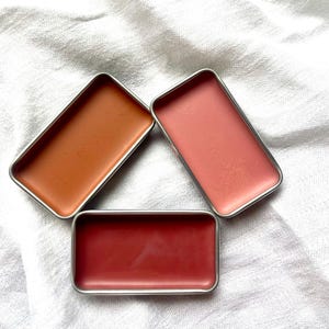 K&ouml;nnte beinhalten: Ein Set aus drei Keramikbechern mit gesprenkelter, matter Oberfl&auml;che. Die Becher sind in Creme-, Hellgrau- und Dunkelgraut&ouml;nen gehalten. Jeder Becher hat ein schlichtes, minimalistisches Design und einen abgerundeten Henkel.