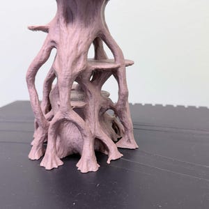 May include: A light brown, 3D-printed structure featuring a central trunk-like column with multiple branching, root-like supports extending outward. The object includes two horizontal, circular platforms integrated within the vertical framework.
