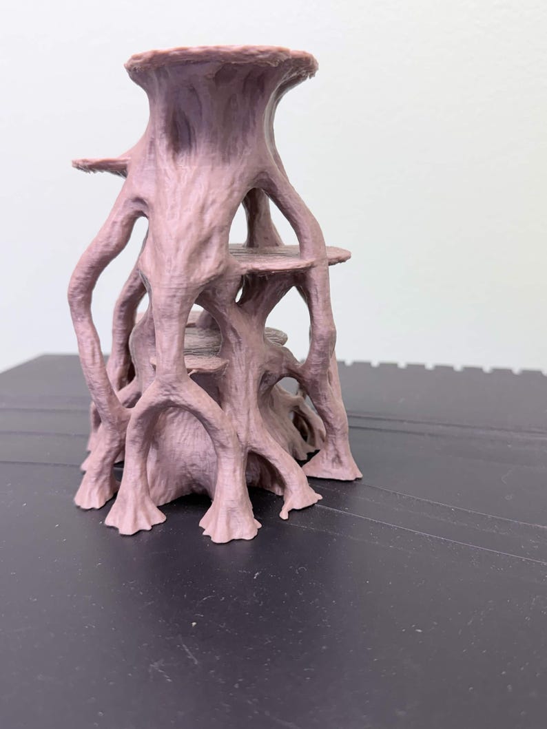 May include: A light brown, 3D-printed structure featuring a central trunk-like column with multiple branching, root-like supports extending outward. The object includes two horizontal, circular platforms integrated within the vertical framework.