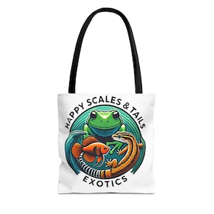 May include: White tote bag with black handles featuring a colorful illustration of a frog, fish, and lizard. The design includes the text "HAPPY SCALES & TAILS EXOTICS" in a circular arrangement. The bag is designed for carrying items.