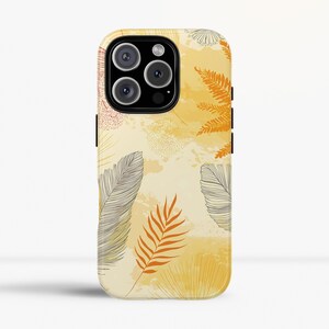 Può includere: Una custodia per telefono con un design botanico. Presenta piume e foglie nei toni del giallo, dell'arancione e del grigio. La custodia ha una finitura lucida e un ritaglio per la fotocamera.