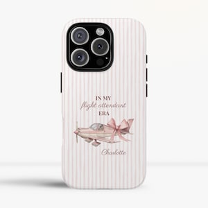May include: A phone case with a pink and white striped background. The case features a pink airplane with a bow, and the text "IN MY flight attendant ERA" and the name "Charlotte".