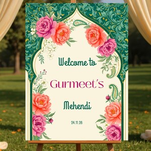 Może przedstawiać: Ozdobny znak na drewnianym sztaludze z napisem "Welcome to Gurmeet's Mehendi 24.11.26". Znak ma kwiatowy wzór z różowymi i pomarańczowymi kwiatami i zielonymi akcentami. Tło obejmuje draperowaną tkaninę i zieleń.