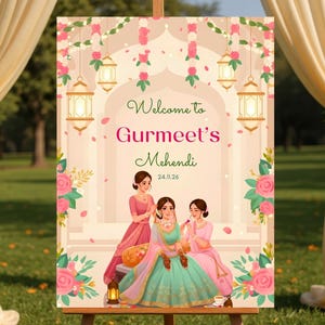 May include: A decorative sign on an easel with the text "Welcome to Gurmeet's Mehendi 24.11.26". The sign features illustrations of women in traditional attire, floral decorations, and hanging lanterns. The background includes draped fabric and a grassy area.