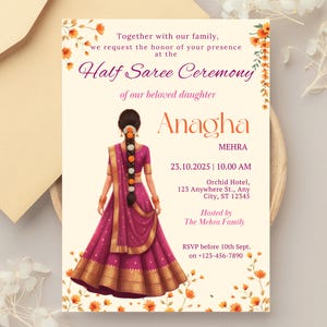 Puede incluir: Invitación para una ceremonia de Half Saree. El diseño presenta a una mujer con un sari magenta y dorado, con detalles florales y texto. La invitación incluye el nombre "Anagha", detalles del evento e información RSVP.
