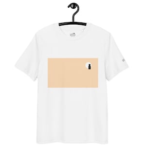 May include: White t-shirt with a minimalist design. It features a peach-coloured rectangle with a black cat silhouette and a white circle, possibly representing the moon. The shirt has short sleeves and a crew neck.