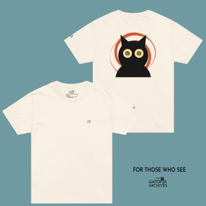 May include: Off-white t-shirts with a black cat graphic on the back, set against a red and orange circular design. The front of the shirt has the word "LOOK" printed in black. The text "FOR THOSE WHO SEE" and "THE GATOPIA ARCHIVES" are printed at the bottom.