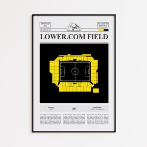 May include: Framed print of Lower.com Field, a soccer stadium in Columbus, OH, with a black and yellow color scheme. The stadium's layout is depicted in yellow against a black background, with text at the top and bottom. The print is in a black frame.