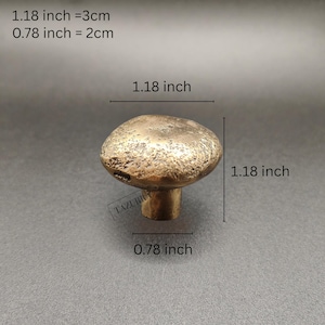 May include: A bronze mushroom-shaped cabinet knob. The knob measures 3 cm in diameter and 2 cm tall. The image text reads: 1.18 inch = 3cm, 0.78 inch = 2cm. The knob has a textured surface.