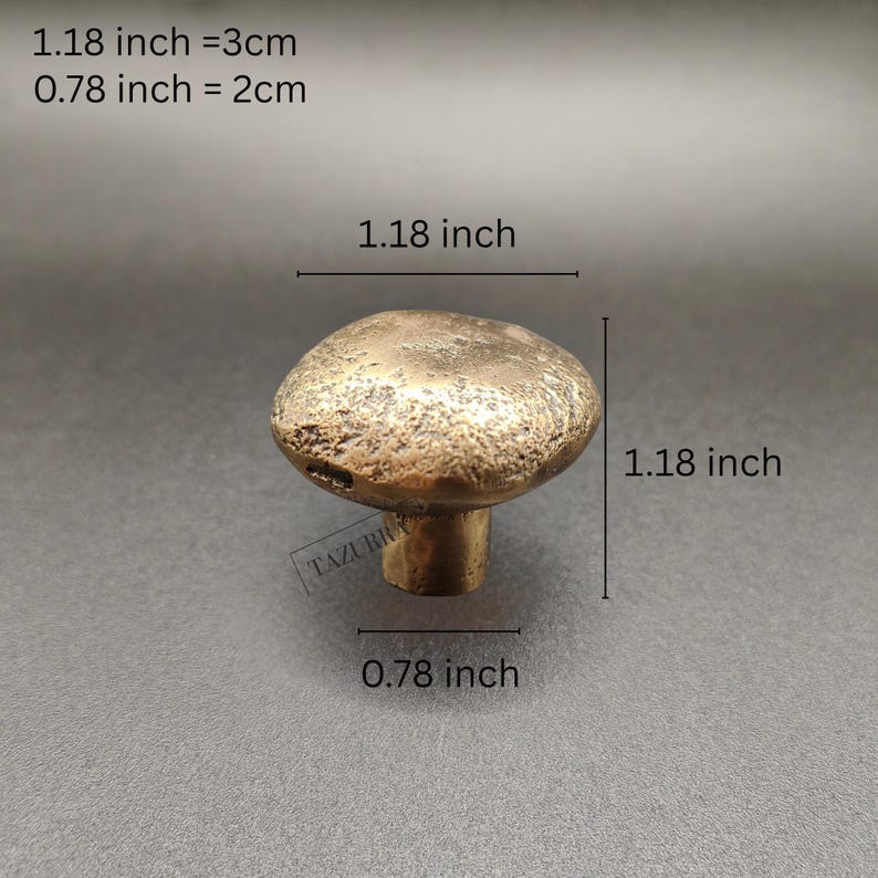 May include: A bronze mushroom-shaped cabinet knob. The knob measures 3 cm in diameter and 2 cm tall. The image text reads: 1.18 inch = 3cm, 0.78 inch = 2cm. The knob has a textured surface.