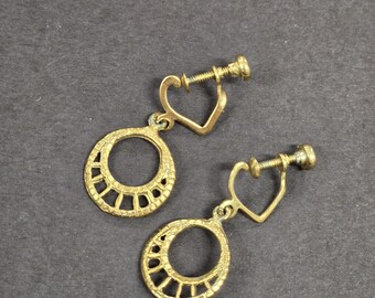 Orecchini vintage a cerchio con chiusura a vite, delicati, color oro. Dettagli dorati.