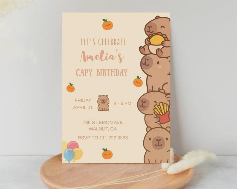 Może przedstawiać: Zaproszenie urodzinowe z jasnobeżowym tłem. Zaproszenie zawiera tekst "Let's Celebrate Amelia's Capy Birthday" oraz ilustracje kapibar i pomarańczy. Uwzględniono r&oacute;wnież datę, godzinę i miejsce.