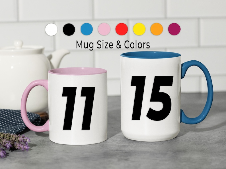 May include: Two white ceramic mugs with black numbers 11 and 15. One mug has a pink interior and handle, the other has a blue interior and handle. The text "Mug Size & Colors" is above the mugs, with color swatches.