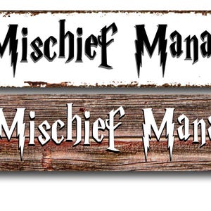 May include: Two rectangular wooden signs with the words "Mischief Manager" in a stylized font. One sign is white with a distressed border, the other is a wood grain pattern. Text on the left says "USA MADE BY ME AT MY HOUSE."