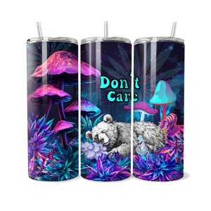 May include: A stainless steel tumbler with a psychedelic design featuring a bear sleeping in a field of mushrooms and marijuana leaves. The text "Don't Care" is printed on the tumbler.