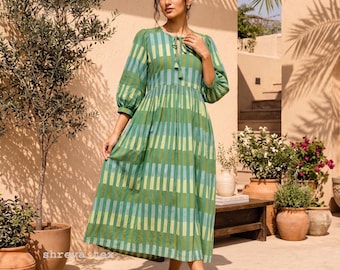 May include: A midi-length dress featuring a vertical striped pattern in shades of forest green, lime green, and light blue. The garment has three-quarter length puff sleeves, a gathered waistline, and a round neckline with a tie-front closure.