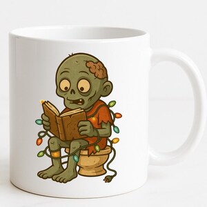 May include: White ceramic mug featuring a cartoon zombie reading a book while sitting on a toilet. The zombie is green with brown hair and wearing a red shirt. Colorful Christmas lights are wrapped around the zombie. The mug has a white handle.