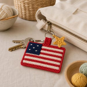Peut inclure: Un porte-clés rectangulaire en crochet représentant le drapeau américain avec des rayures horizontales rouges et blanches et un canton bleu avec des étoiles blanches. Une petite étoile jaune en crochet est fixée à l'anneau en métal.