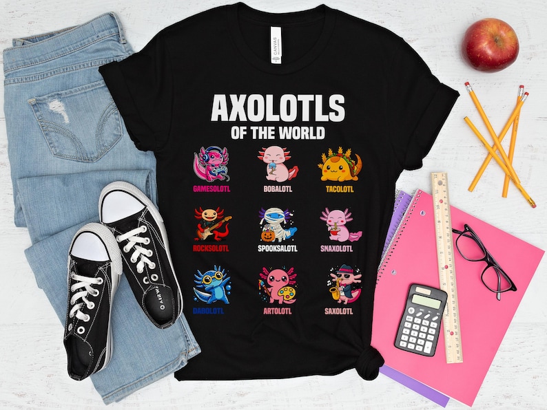May include: Black t-shirt with the text "AXOLOTLS OF THE WORLD" and cartoon axolotl characters. The axolotls are depicted in various styles, including a gamer, a musician, and a taco-themed axolotl. The shirt is paired with jeans and black sneakers.
