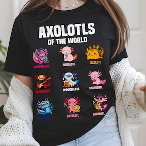 May include: Black t-shirt with the text "AXOLOTLS OF THE WORLD" above nine cartoon axolotl characters. Each axolotl is uniquely designed, including one with headphones, one as a taco, and one playing a guitar.