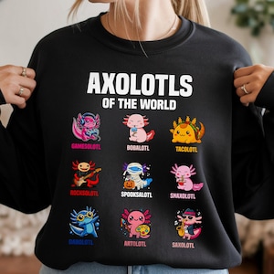 May include: Black sweatshirt with the text "AXOLOTLS OF THE WORLD" in white. Below the text are nine colorful axolotl illustrations, each with a unique theme, including a gamer, a taco, and a rockstar.