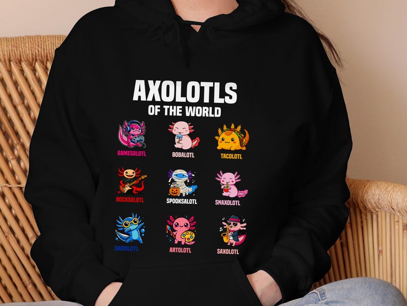 May include: Black hoodie featuring the text "AXOLOTLS OF THE WORLD" above nine cartoon axolotls, each with a unique design and name. The axolotls are in various colors and styles, including a gamer, a taco, and a musician.