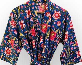 May include: A blue floral print robe with a matching belt. The robe features a vibrant pattern of red and pink flowers with yellow accents on a dark blue background. White trim edges the sleeves and lapels.