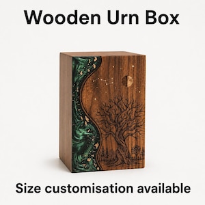 May include: A rectangular wooden urn box featuring a dark wood grain finish. The front panel displays a vertical, wavy inlay of swirling green resin with gold leaf accents, alongside a laser-engraved tree, forest, and moon constellation.