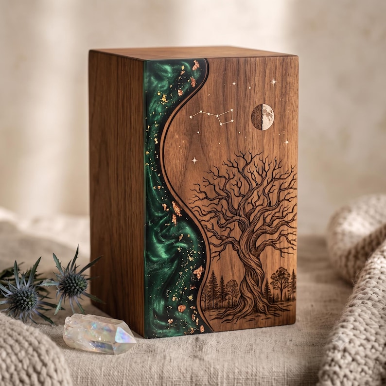 May include: A rectangular wooden urn featuring a dark walnut finish with a vertical, wavy inlay of emerald green resin infused with gold leaf flakes. The wood surface is laser-engraved with a detailed tree, a crescent moon, and a star constellation.