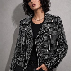May include: A black biker jacket covered in small silver rhinestones, featuring a notched lapel, silver-tone metal zips on the front and cuffs, and a small flap pocket. The text Bellachicvibes with a heart symbol is visible in the top left corner.