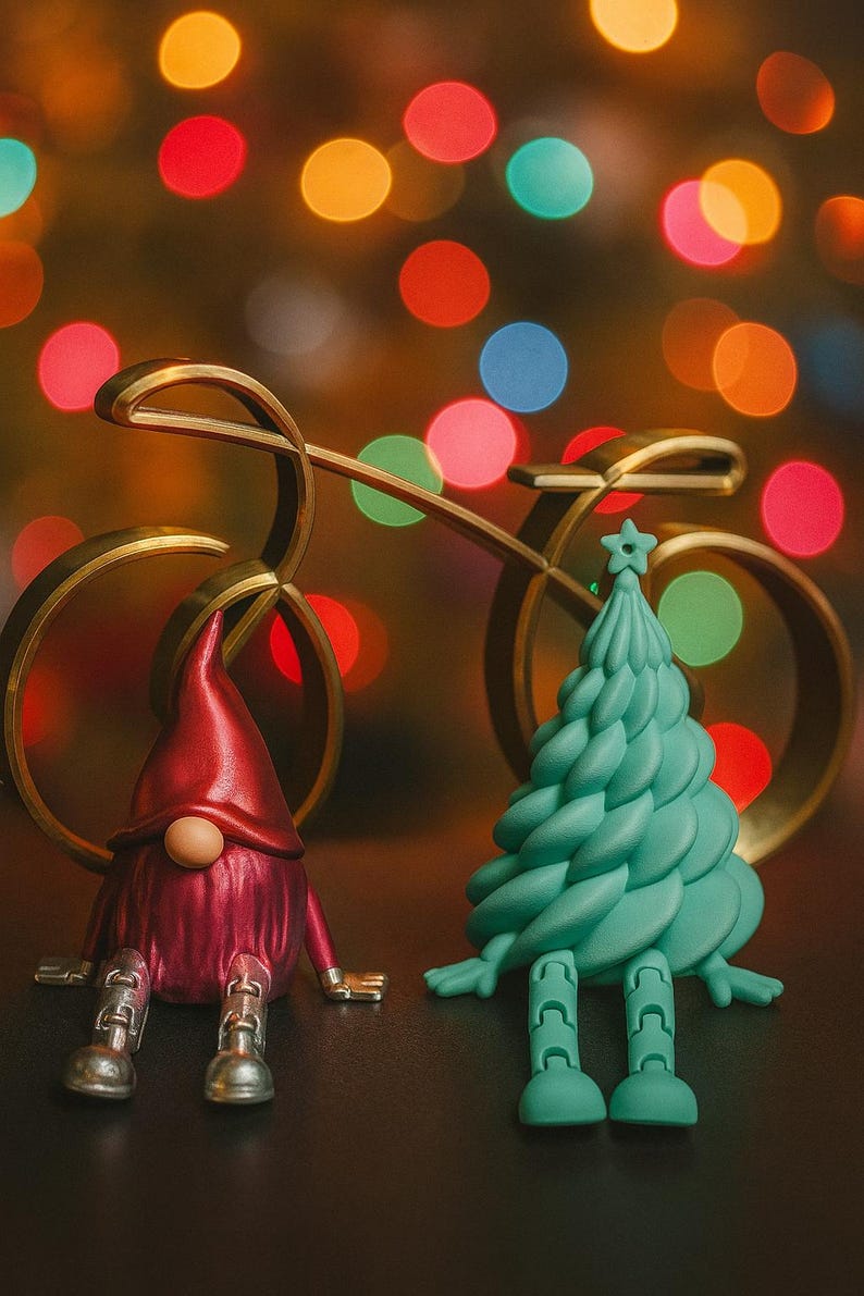 K&ouml;nnte beinhalten: Eine skurrile Weihnachtsszene mit einem roten Zwerg und einer t&uuml;rkisfarbenen Weihnachtsbaumfigur. Im Hintergrund befindet sich ein goldener Fahrradschmuck mit bunten Bokeh-Lichtern. Der Zwerg hat silberfarbene F&uuml;&szlig;e, und der Baum hat einen Stern oben drauf.