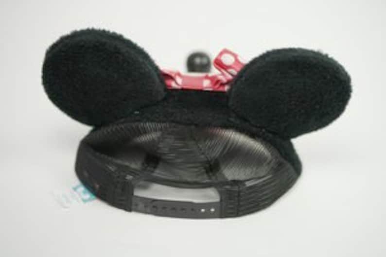 Pu&ograve; includere: Cappellino da baseball in rete nera con orecchie di topo pelose nere. Il cappello ha un cinturino regolabile rosso con una fibbia di plastica.