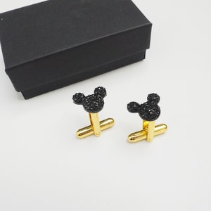 May include: A pair of gold cufflinks with black crystal Mickey Mouse heads.