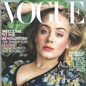 Peut inclure: Couverture du magazine Vogue avec Adele. La couverture comprend le logo Vogue, le mot "Angel" et le mois "Mar". Le texte comprend "Welcome to the Revolution!" et "Spring's Extraordinary Change". Adele porte un haut bleu foncé avec des ornements colorés.