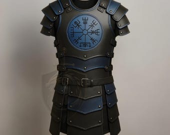 Puede incluir: Un peto de cuero negro y azul con un emblema circular azul. La armadura presenta placas superpuestas en los hombros y el pecho, con una serie de correas y hebillas de cuero. El diseño incorpora una estética de inspiración vikinga.