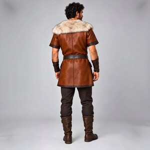 Men’s Viking leather tunic costume in brown leather with a wide fur shoulder collar, dark brown trim, adjustable buckle closures, waist belt, utility pouches, and matching leather forearm bracers. Front and back views show the knee-length Norse warrior tunic with short sleeves, fur across the shoulders, fitted belt, and medieval detailing. Ideal for Viking cosplay, LARP, Renaissance fairs, Halloween, fantasy events, and Norse warrior costumes.