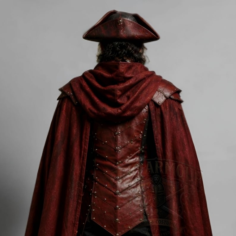 Men's leather pirate costume in dark red and black, featuring a detailed leather vest, layered shoulder armor, arm bracers, leg armor, and flowing cape. Handmade pirate cosplay outfit for Halloween, LARP, Renaissance fairs, medieval fantasy events, themed parties, festivals, conventions, stage performances, and photoshoots. Custom sizing, colors, length, and design options available. Dark fantasy pirate captain costume with wearable leather armor and handcrafted details.