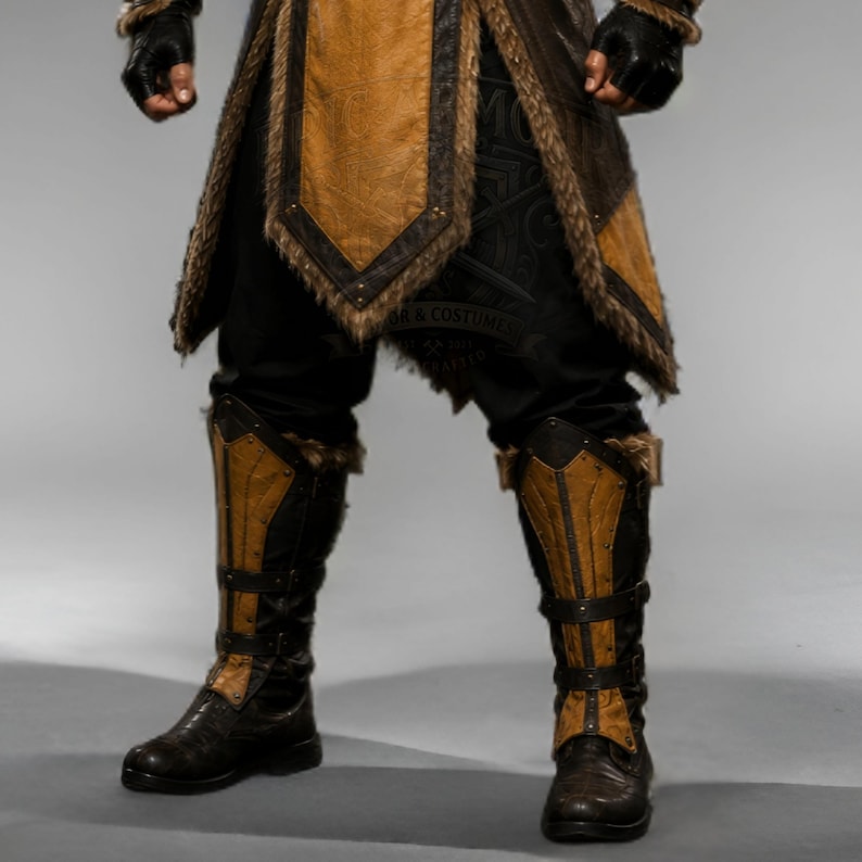 Black leather Viking ninja armor costume with antique gold leather panels, fur-trimmed shoulders, deep hood, adjustable waist belt, layered front armor, matching leather arm bracers, wrist guards and lower leg armor. Handmade medieval fantasy outfit with a rugged warrior-inspired design, suitable for Halloween, LARP, cosplay, Renaissance fairs, conventions, themed parties and fantasy photoshoots. Custom sizing and color options available.