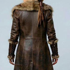 Women’s brown Viking leather fur coat costume featuring a dramatic fur-trimmed collar, long medieval warrior silhouette, fitted waist, front metal closures, leather belt, matching pants, wrist guards, and lace-up boots. Handmade Shieldmaiden-inspired outfit for Halloween, Viking cosplay, LARP events, Renaissance fairs, medieval festivals, fantasy conventions, Norse-themed parties, winter events, stage performances, warrior photoshoots, and custom made-to-measure costume styling for cosplay fans