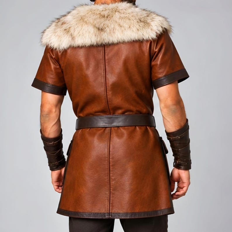 Men’s Viking leather tunic costume in brown leather with a wide fur shoulder collar, dark brown trim, adjustable buckle closures, waist belt, utility pouches, and matching leather forearm bracers. Front and back views show the knee-length Norse warrior tunic with short sleeves, fur across the shoulders, fitted belt, and medieval detailing. Ideal for Viking cosplay, LARP, Renaissance fairs, Halloween, fantasy events, and Norse warrior costumes.