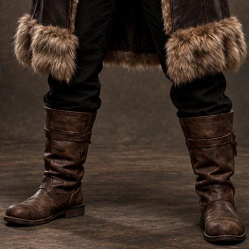 Men’s Viking warrior leather coat in rugged brown with a long medieval silhouette, wide synthetic faux fur collar, fur-trimmed cuffs and hem, front leather straps, metal buckle closures, and detailed stitched panels. The costume is styled over dark clothing for a bold Norse warrior look. Ideal for Viking cosplay, medieval LARP, Renaissance fairs, Halloween costumes, fantasy events, themed parties, stage performances, conventions, and dramatic medieval photoshoots.