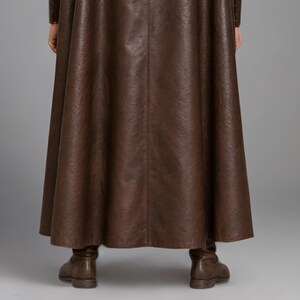 Men’s brown Viking leather tunic with a full-length matching cloak, large light fur shoulder collar, lace-up neckline, wide leather belt, front utility pockets, and matching leather forearm bracers. Front and back views show the sleeveless Norse warrior tunic and long flowing fur-trimmed cloak. Ideal for Viking cosplay, medieval LARP, Renaissance fairs, Halloween, fantasy conventions, stage costumes, and Norse warrior events.